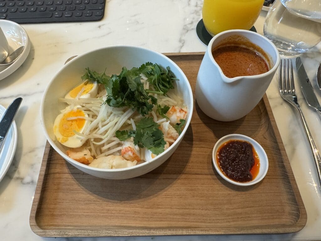 Singaporeansk laksa med hummer, kokt ägg och böngroddar